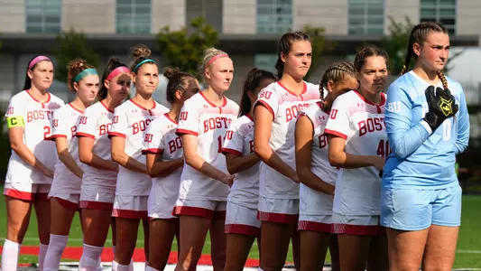 Photo of the women's soccer team lining up for the national anthem.