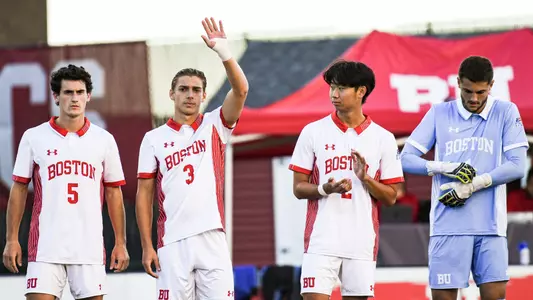 Gianluca Arlotti waves hand toward the crowd during starting lineup introductions with teammates standing next to him.