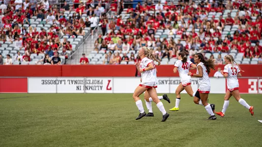 Photo of the women's soccer team running out after scoring a goal against UMass in 2021.