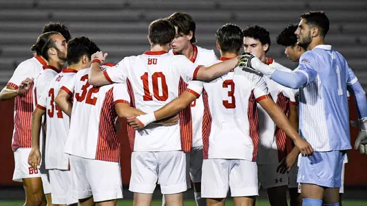 BU men's soccer starters huddle on the field before the start of the game against Army.