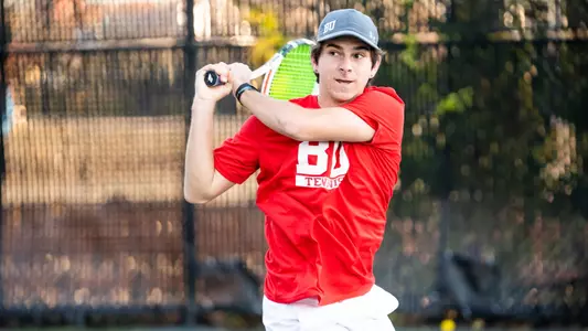 Adrian Pawlowski follows through on a double backhand on a tennis shot.