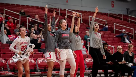 Photo of the women's basketball team bench celebrating a play.