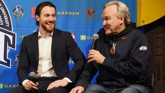 Matt and John Grzelcyk sitting together on stage at the Beanpot Luncheon