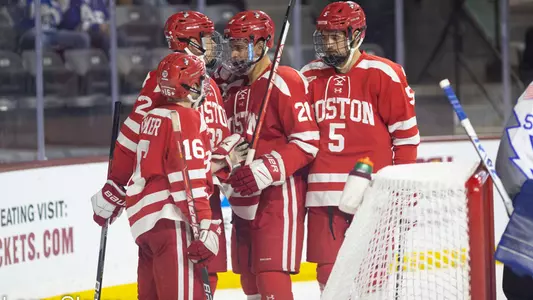 The men's ice hockey team celebrates a goal