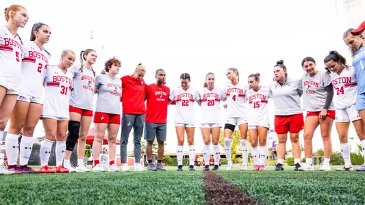 Photo of the Women's Soccer team huddling before the game against Colgate.