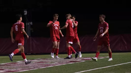 Alex Bonnington celebrates an early first-half goal at Harvard by hugging teammates.
