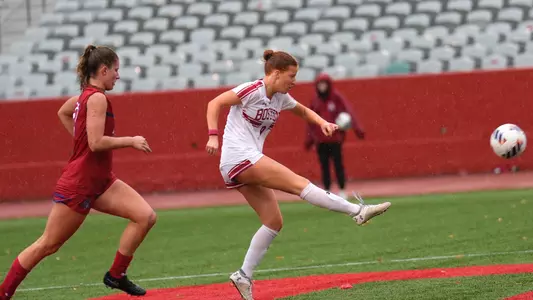 Photo of women's soccer sophomore Margy Porta going for a shot against American.