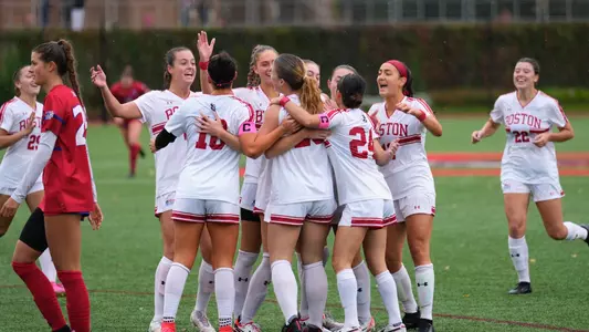 Photo of the Women's Soccer team celebrating a goal at Nickerson Field.