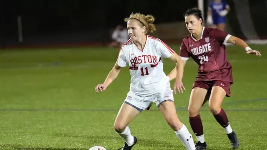 Photo of women's soccer junior Erin Sullenberger dribbling past a Colgate defender.