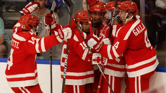 Men's ice hockey players celebrate a goal at Bentley
