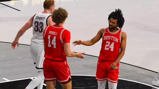Miles Brewster and Nico Nobili slap hands after a play at Northeastern