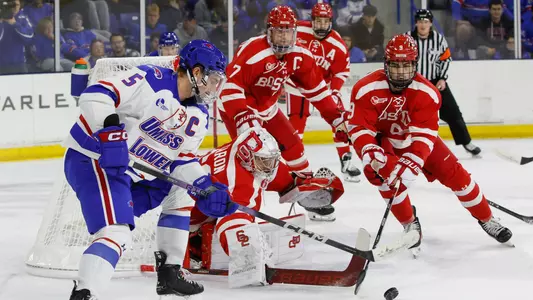 Mathieu Caron pokes the puck away from a UMass Lowell attacker