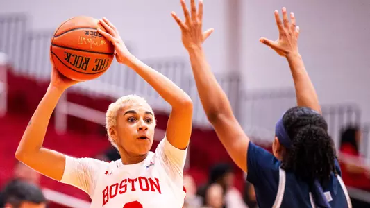 Photo of women's basketball senior Kelsi Mingo looking to pass the ball against UNH.
