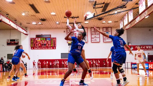 Photo of women's basketball senior Caitlin Weimar attempting the game-winning hook shot against UMass Lowell.