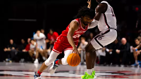 Miles Brewster dribbles hard past a Northeastern defender