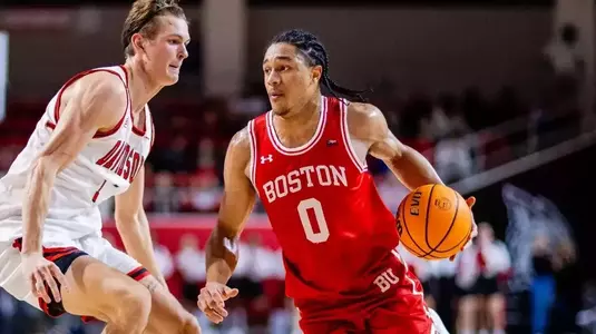 Matai Baptiste handles the ball while guarded by a Davidson defender.