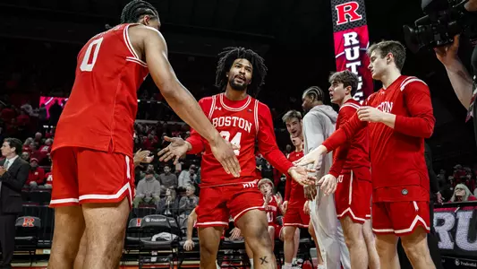 Miles Brewster slaps hands with teammates going through a starting lineup tunnel at Rutgers.