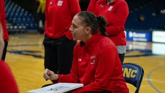 Photo of BU Women's Basketball Head Coach Melissa Graves in a team huddle.