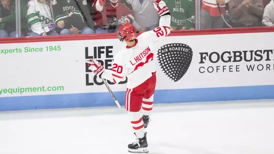Shot from above and behind Lane Hutson as he looks towards the crowd while celebrating a goal at Agganis