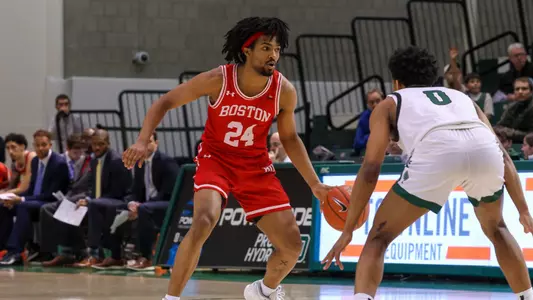 Miles Brewster dribbles the ball up the court with a Dartmouth defender in front.