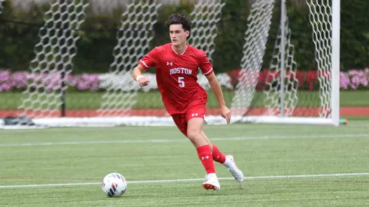 Griffin Roach dribbles the ball up the field from the BU goalie box