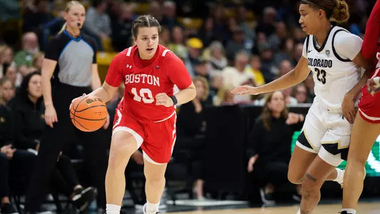 Photo of women's basketball junior Alex Giannaros dribbling down the lane against Colorado.