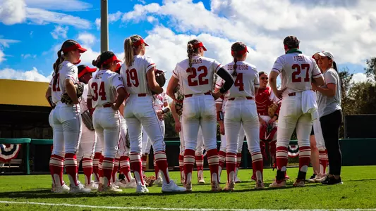 Boston University softball team huddles in a circle at South Florida with Coach Waters talking to the team.