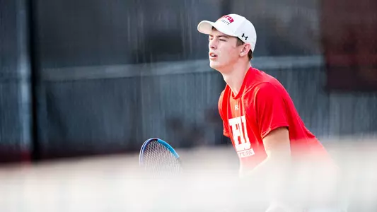 Cole Knutsen holds the racquet near the net waiting for the ball.