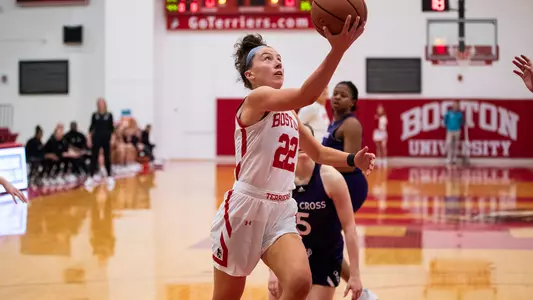 Photo of women's basketball senior Maggie Pina going for a layup against Holy Cross.