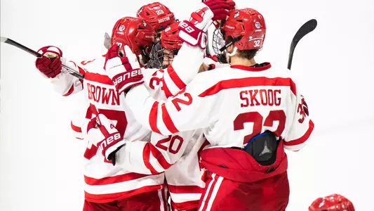 Four BU men's ice hockey players celebrate a goal