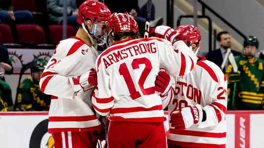 The men's ice hockey team celebrates a goal