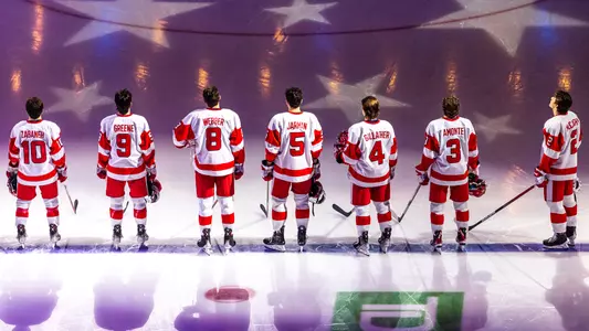 The men's ice hockey team standing on the blue line at TD Garden during the national anthem