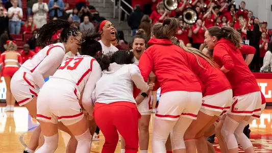 Photo of the women's basketball team huddling before a game.