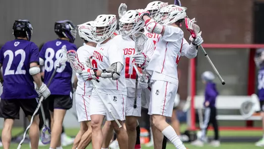 Men's lacrosse team celebrating a goal against Holy Cross