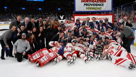 The men's ice hockey team poses with the Lamoriello Trophy after winning the 2023 Hockey East title