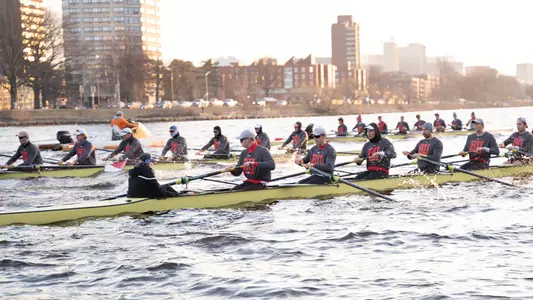 Photo of the men's rowing team at practice, with the 2V8 in the foreground.