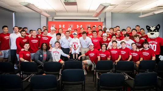 The men's lacrosse team poses for a group photo with Ben, their new teammate through Team IMPACT, at Ben's signing day