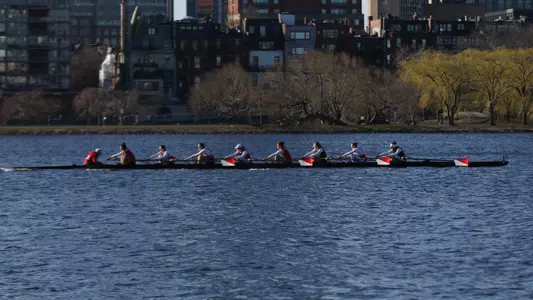 Photo of the BU Women's Rowing 2V8 racing on the Charles River against Dartmouth.