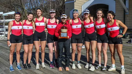 Photo of the Lightweight Rowing Varsity 8 hoisting the Beanpot trophy.