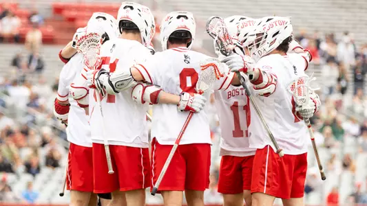 Men's lacrosse players celebrate a goal