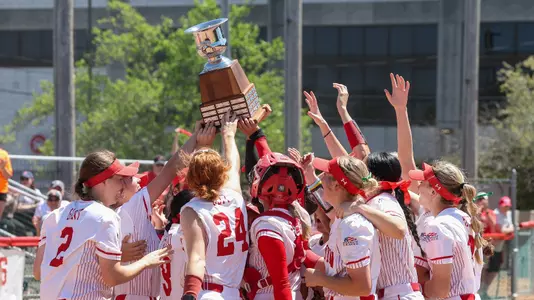 Boston University softball hoists the Patriot League championship trophy as a group