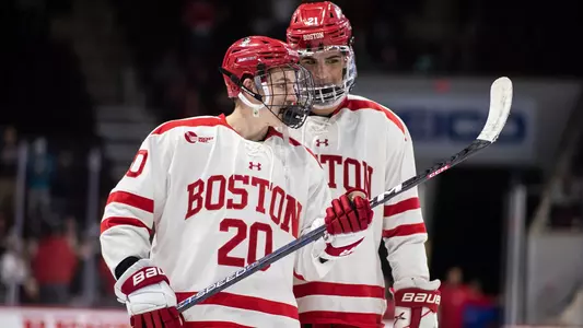 Lane Hutson talking to Devin Kaplan on the ice during a game