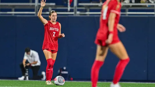 Photo of women's soccer junior Eileen Solomon putting her hand in the air before a free kick.
