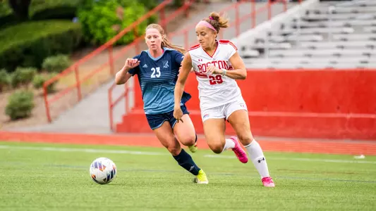 Photo of women's soccer junior Morgan Fagan dribbling past a Rhode Island defender.