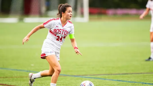 Photo of senior Lily Matthews dribbling the ball at Nickerson Field.