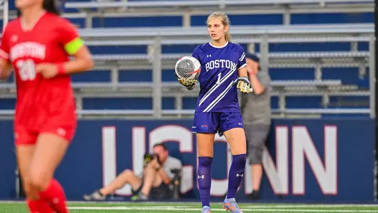 Photo of women's soccer junior Celia Braun holding the ball while looking to pass.