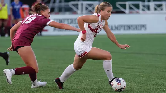 Photo of women's soccer sophomore Natalie Godoy dribbling around a Colgate defender.