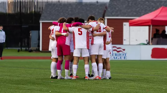 Men's Soccer team's starters huddle before the start of the Holy Cross game.