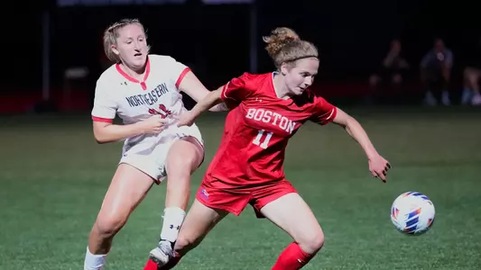 Photo of women's soccer junior Erin Sullenberger battling for possession with a Northeastern player.