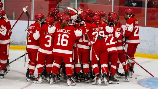 Women's Hockey huddles to celebrate Win at McGill